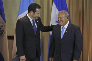 Morales (izquierda) platicando con su homólogo de El Salvador. (AP)