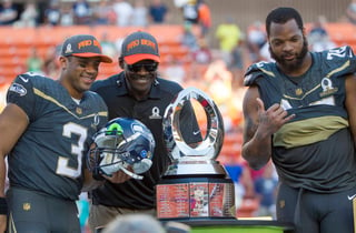 El jugador más valioso del Pro Bowl, Russell Wilson (i) posa para la fotografía con Michael Irvin y el trofeo de ganadores. (AP)