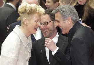 La actriz Tilda Swinton bromeando junto a George Clooney y el director Ethan Coen. (EFE)