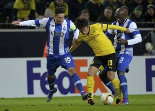 El jugador del Borussia Dortmund Shinji Kagawa (c) lucha por el control del balón con Héctor Herrera (i) y Bruno Martins Indi (d), del Porto. (EFE)