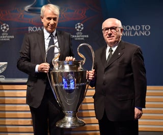 Carlo Tavecchio, presidente de la federación del Calcio italiano (i), y Giuliano Pisapia, alcalde de Milán, posan junto al trofeo que se llevará el campeón de la Liga de Campeones de Europa. (AP)