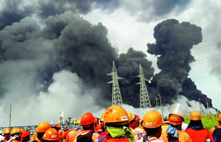 Asombro. Varios trabajadores de la Planta de Pajaritos de Pemex observan las enormes columnas de humo del incendio. (EL UNIVERSAL)