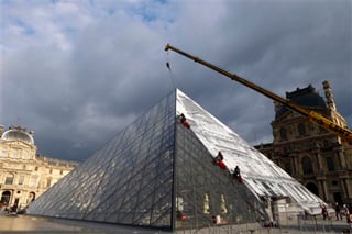 El artista cubrió la enorme pirámide de vidrio con una instalación trampantojo que da la impresión de que el monumento, en el corazón de la plaza Napoleón, ha desaparecido. (AP)
 