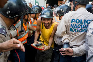 De compras. Un hombre sale de una multitud tras haber comprado un par de sopas, ante la escasez que existe en Venezuela. (EFE)
