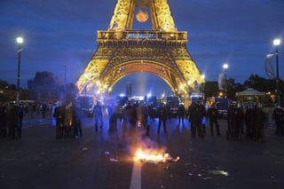 Antidisturbios franceses forman un cordón de seguridad durante los altercados en los alrededores de la zona de fans instalada en la Torre Eiffel. Detienen a 1,550 durante la Eurocopa