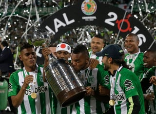 El colombiano Miguel Ángel Borja, autor del único gol del partido, le da un beso al trofeo de campeón. (AP)
