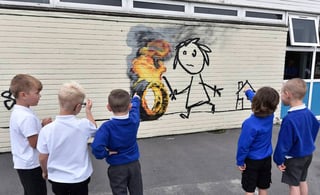 Libre. Niños del Bridge Farm Primary School ven una obra de Banksy que apareció en su patio.