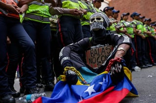Protesta. Un estudiante protesta frente a policías para pedir la revocación de Maduro. 