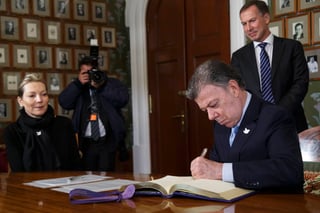 Galardón. El presidente de Colombia, Juan Manuel Santos, firma el libro de protocolo en el Instituto Noruego Nobel en Oslo. (AP)