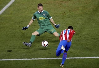 El delantero del Atlético Ángel Correa (d) lanza a puerta ante el portero Raúl Lizoain, de Las Palmas, para anotar el segundo gol del equipo. Atlético de Madrid cae, pero sigue adelante