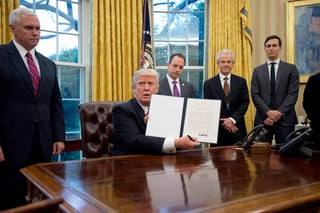 Primer paso. El presidente estadounidense, Donald Trump (c), muestra la orden ejecutiva para sacar a su país del acuerdo comercial TPP, en el Despacho Oval de la Casa Blanca, rodeado de una parte de su gabinete. (EFE)