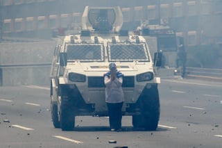 Defensa. Una de las participantes de manifestaciones en contra del gobierno de Nicolás Maduro, se puso enfrente una vehículo de la Guardia Nacional Bolivariana para bloquear su paso.