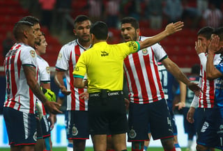 Hedgardo Marín (i), del Chivas, y Jair Pereira (d) en una discusión con el árbitro central durante el partido de anoche.  (Jam Media)