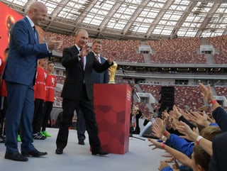 El brasileño Roberto Gama de Oliveira, 'Bebeto', campeón mundial en 1994, fue el encargado de subir la copa al escenario y cedérsela a Putin, quien no dudó en descender al terreno de juego para darse un baño de multitudes. (EFE)