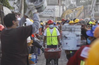 Cansancio. Rescatistas y voluntarios realizan trabajos de remoción de escombros en el poblado de San Gregorio.