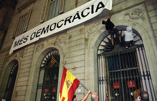 Tensión. Dos personas intentan arrancar la pancarta con la leyenda 'Más democracia' en el ayuntamiento de Barcelona, una muestra de la tensión que priva por el referéndum independentista.