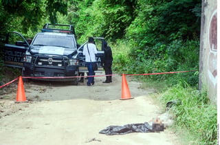 Crimen. Agentes estatales de Guerrero acudieron al Paso Texca, donde fue encontrado un cadáver en una bolsa negra. (AGENCIA REFORMA) 