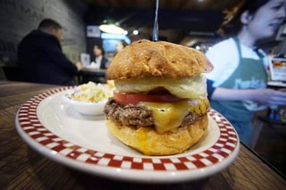 La 'Combinación Presidente Trump', nueva adición al menú de Munch's Burger, incluye una hamburguesa con queso, una porción de ensalada de repollo y papas fritas, y se vende por 1,400 yenes (12 dólares). (AP)