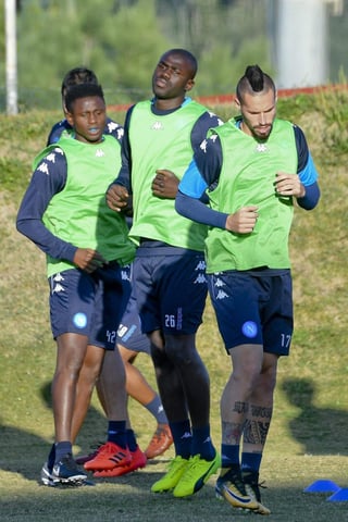 Los jugadores del Nápoles Amadou Diawara, Kalidou Koulibaly (c) y Marek Hamsik (derecha) calientan durante el entrenamiento del equipo en Castel Volturno, Nápoles.