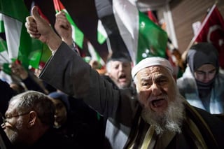  Manifestantes gritan consignas contra el presidente de los Estados Unidos, Donald Trump, durante una protesta donde sostienen banderas turcas y palestinas. (EFE) 