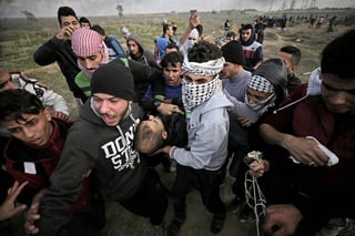 Lucha. Manifestantes palestinos portan el cuerpo sin vida de Yasser Sokar, de 23 años. 