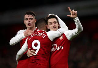 Mesut Ozil (d) celebra su gol, tercero del Arsenal, en el juego de ayer. (AP)