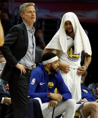 El jugador de los Warriors de Golden State Stephen Curry observa a su entrenador durante un partido de la NBA. (AP)