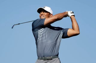 Tiger Woods suelta el palo de golf al realizar un tiro en el 12do hoyo del torneo Farmers Insurance Open.
