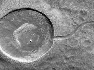 Muestra un cráter de impacto, el cual parece un renacuajo tallado por el agua que lo abastecía. (NASA)