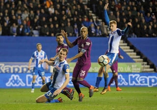 Fernandinho, del Manchester City, ve cómo se le escapa una oportunidad entre dos jugadores del Wigan. (AP)