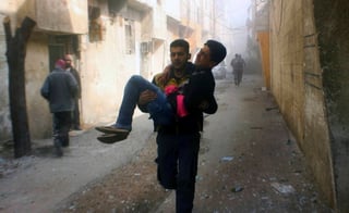 Sin descanso. Una persona carga a joven herido en uno de los bombardeos de ayer en Guta Oriental, Siria.