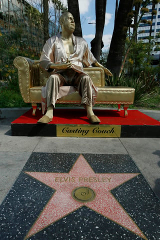 Una estatua dorada de Harvey Weinstein vestido con una bata, sentado imponentemente en un sofá con un Oscar. (ARCHIVO)
