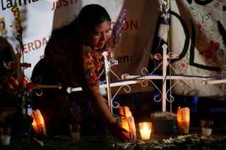 Memoria. Mujeres de varias organizaciones de derechos humanos y de la mujer colocan velas en honor a las víctimas del incendio. (EFE)