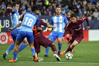 El delantero brasileño del Barcelona Philippe Coutinho (d) se lleva el balón ante varios rivales del Málaga. (EFE)