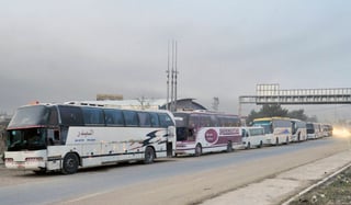 Salida. Una treintena de autobuses con 1,723 personas, de las que 398 son combatientes, están listos para partir hacia Idleb. (AP)