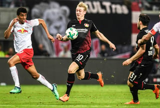 Julian Brandt (c), de Leverkusen, disputa el balón con Bernardo (i) de Leipzig, durante un partido de la Bundesliga. Leverkusen arrolla a Leipzig y lo desplaza en la tabla