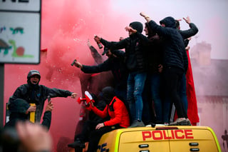 Fanáticos de futbol sobre una camioneta de la policía afuera del Anfield Stadium en Liverpool, Inglaterra, en la semifinal de ida. (AP)