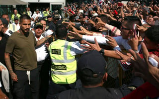 El capitán de la selección de Perú Paolo Guerrero (izquierda) recibe el saludo de hinchas al llegar a Lima, Perú, ayer. Guerrero busca acciones legales por suspensión
