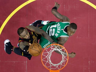 LeBron James, izquierda, de los Cleveland Cavaliers ataca el aro en contra de Terry Rozier de los Boston. (AP)
