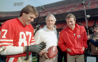 En esta fotografía de archivo del 16 de junio de 1985, el entrenador en jefe de los 49ers de San Francisco, Bill Walsh (c) sonríe con el quarterback, Joe Montana (16), y el receptor Dwight Clark (i). (Archivo)