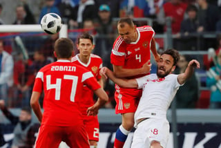 El turco Kenan Karaman (d) disputa el balón con los rusos Roman Zobnin (i) y Sergey Ignashevich (2-dch) durante un partido amistoso. (EFE)