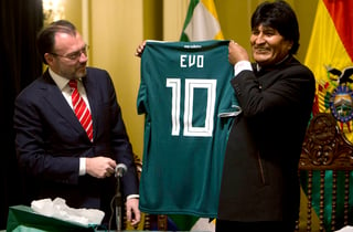 Acompañado por el secretario de Relaciones Exteriores de México Luis Videgaray, el presidente boliviano Evo Morales muestra una camiseta de futbol con su nombre, durante una conferencia de prensa en mayo. (AP)
