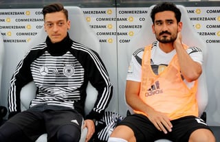 Mesut Ozil (i.) e Ilkay Gundogan, de la selección de Alemania, se sientan en el banquillo durante un partido amistoso ante Arabia Saudí. Críticas a dos jugadores preocupan a técnico alemán