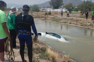 Rescate. El vehículo fue sacado del agua por personal de Protección Civil y los Buzos Castañeda. (EL SIGLO DE TORREÓN)