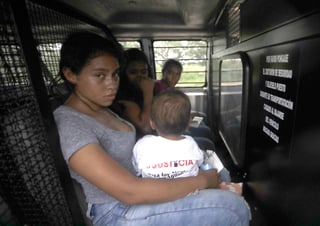 Proceso. Una madre hondureña carga a su niño de un año en una camioneta después de entregarse a la Patrulla Fronteriza. (AP)