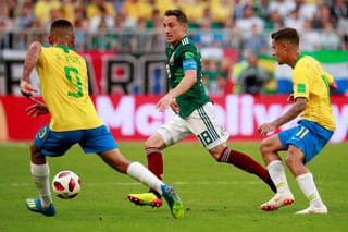 El capitán del equipo mexicano, Andrés Guardado, trata de pasar entre dos adversarios.