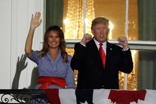 Celebran. Donald Trump saluda junto a Melania Trump, desde un balcón de la Casa Blanca durante los fuegos artificiales. (EFE)