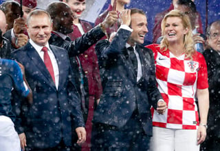 Vladimir Putin, presidente de Rusia, Emmanuel Macron, presidente de Francia y Kolinda Grabar-Kitarovic, presidenta de Croacia, bajo la lluvia en la entrega de medallas. (AP)