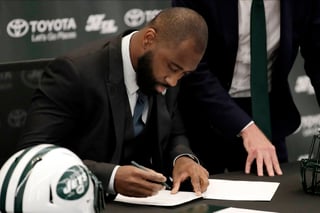 Darrelle Revis firma un contrato de un día con los Jets de Nueva York durante la conferencia de prensa en la que anuncia su retiro oficial. (AP)