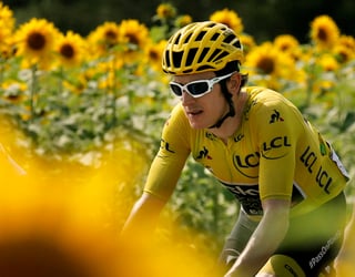 El británico Geraint Thomas, con la casaca amarilla de líder general, cruza por campos de girasoles durante la 18va etapa del Tour de Francia. (AP)